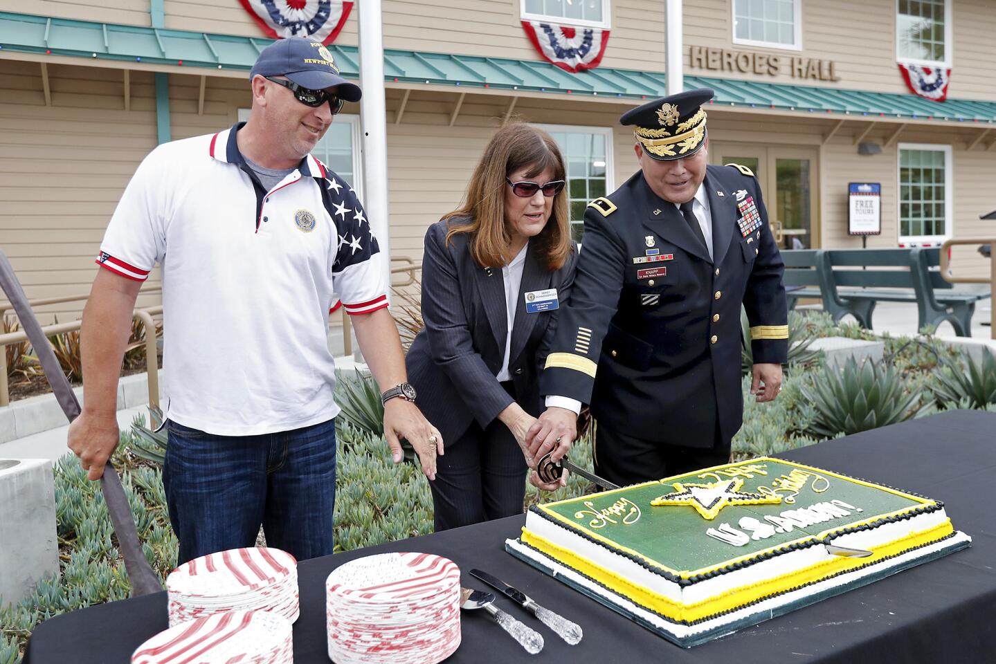 From left, Nick Giordano of American Legion Newport Harbor Post 291, Post 291 3rd Vice Commander Sandy Schneeberger and Brig. Gen. Denton Knapp, commander of the Army component of the California State Military Reserve, cut the ceremonial cake as they celebrate the Army's 244th anniversary Friday at Heroes Hall in Costa Mesa.
