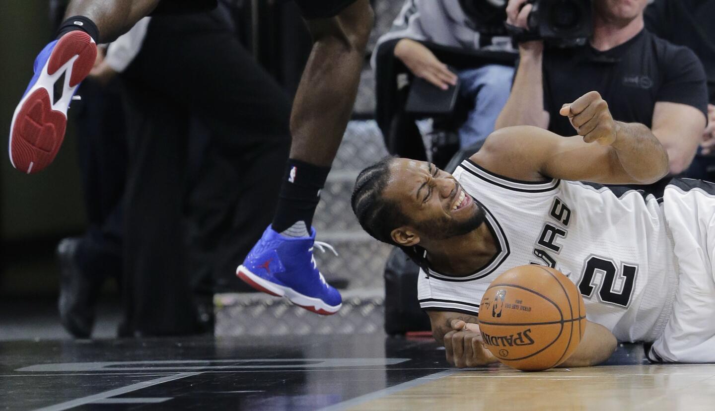 Spurs forward Kawhi Leonard (2) crashes to the floor after he was bumped by Clippers forward Jeff Green during the first half.