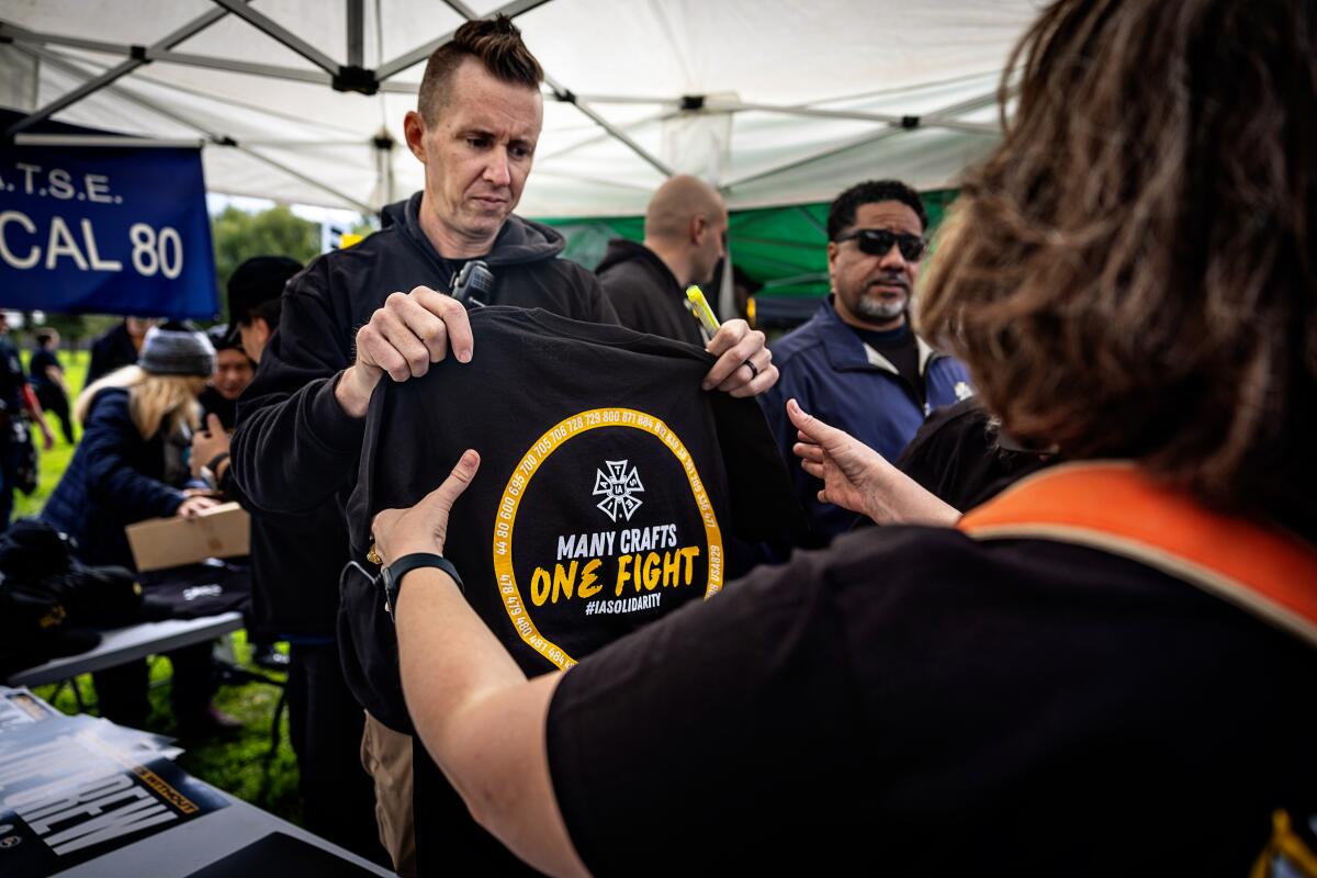 Corey Moore passes out a "Many Crafts One Fight" T-shirt to one of his members.