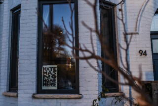 A "hate has no home here" sign is posted in the window of a residence