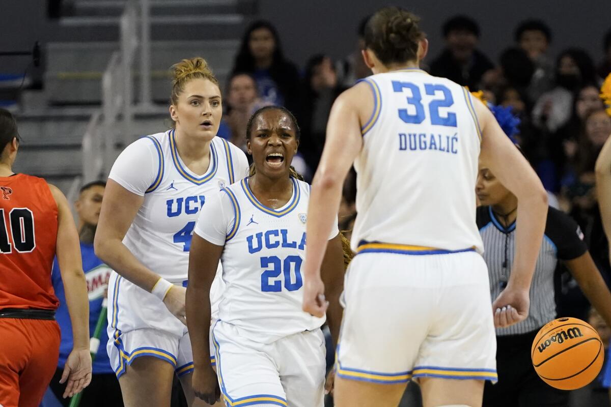UCLA guard Charisma Osborne, center, reacts toward teammate Angela Dugalic.