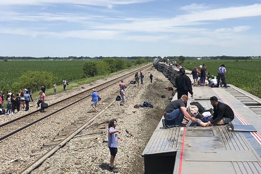 An Amtrak passenger train lies on its side after derailing near Mendon, Mo.