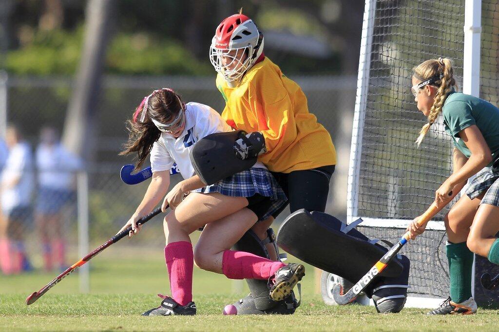 Newport Harbor High's Riley Flanagan, left, battles Edison goalkeeper Hannah Heydorff, center, during the second half in a Sunset League game at Davidson Field on Tuesday.