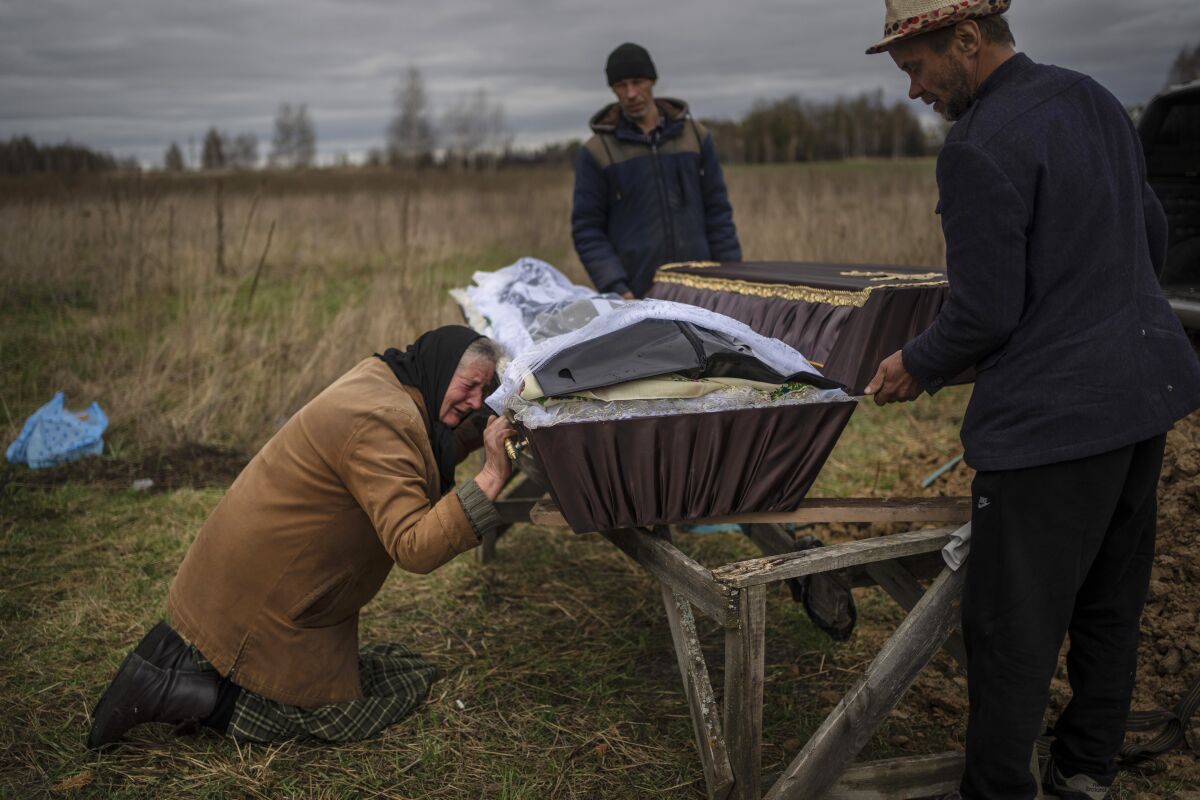 FILE - Nadiya Trubchaninova cries over the coffin of her son, Vadym, who was killed on March 30 by Russian soldiers in Bucha, Ukraine, during his funeral in the cemetery of nearby Mykulychi, on the outskirts of Kyiv, on April 16, 2022. Nobody knows how many civilians have died in the 100 days since Russia's invasion of Ukraine, but one thing is certain: the toll reaches into the tens of thousands. (AP Photo/Rodrigo Abd, File)