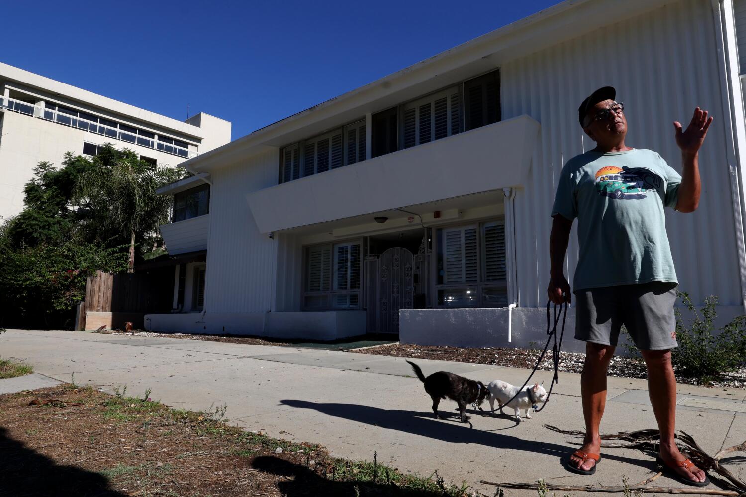 SANTA MONICA, CA - OCTOBER 16, 2025 -- Santa Monica resident Alex Ardeshir, 57, is opposed to a former senior assisted living facility, background, to be converted as supportive housing for homeless with serious mental illness at 825 Ocean Avenue in Santa Monica on October 16, 2025. Ardeshir feels that mentally ill homeless need to be housed at a proper place to suit their needs. Two multi-million dollar beachfront properties on Ocean Avenue were slated to become housing for the homeless as part of the Behavior Health Bridge Housing (BHBH) Program in Santa Monica. The project has since been paused for community engagement. (Genaro Molina/Los Angeles Times) A former senior assisted living facility at 413 and 425 Ocean Avenue is being converted into a 49-bed transitional housing program for formerly homeless individuals with serious mental illness, operated by the St. Joseph Center and funded by Los Angeles County