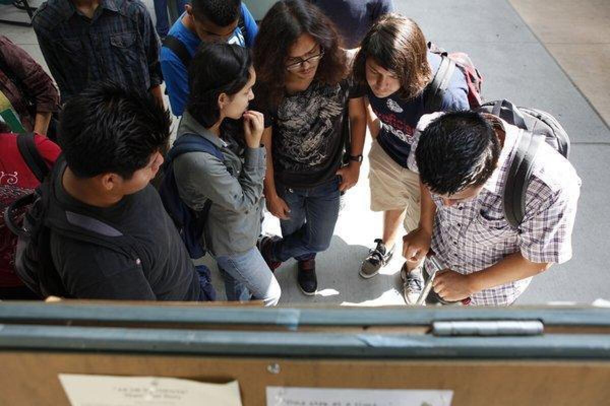 Students check course schedules at East Los Angeles College in June 2012. A new study reports that while more students are passing remedial math and English courses, fewer are finishing college or transferring.