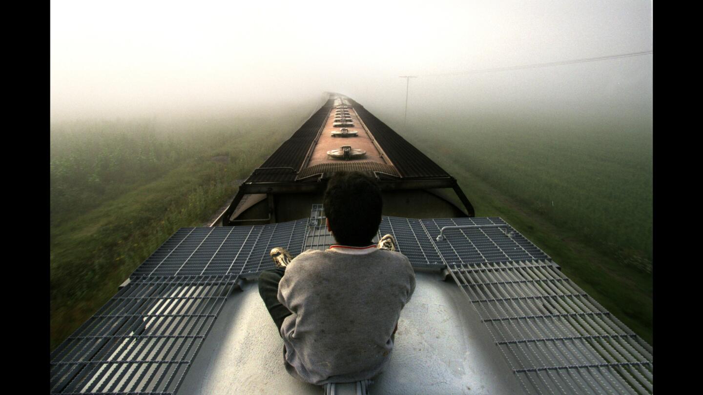 A Central American youth rides a freight train through Mexico toward the United States. Each year, thousands of children cling to the tops and sides of trains as they journey north in search of a parent. Some say they need to find out whether their mothers still love them.