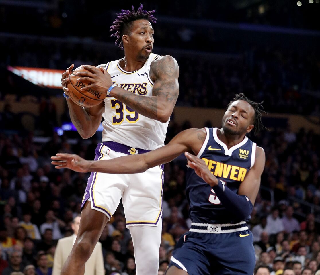Lakers center Dwight Howard pulls a rebound away from Nuggets forward Jerami Grant.