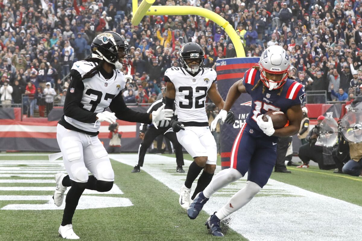 New England Patriots wide receiver Kristian Wilkerson, right, scores a touchdown against Jacksonville Jaguars Tre Herndon (37) and Tyson Campbell (32) during the first half of an NFL football game, Sunday, Jan. 2, 2022, in Foxborough, Mass. (AP Photo/Paul Connors)