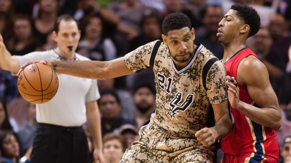 San Antonio Spurs forward Tim Duncan, left, is guarded by New Orleans Pelicans forward Anthony Davis during the Spurs' loss on Saturday.