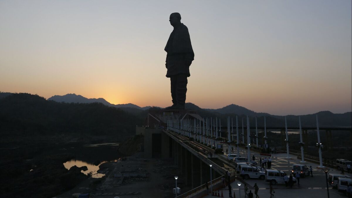 The Statue of Unity is silhouetted against the setting sun in the Narmada district of Gujarat state, India.