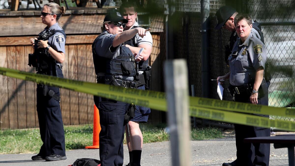 Investigators gather at the site where a gunman opened fire in Alexandria, Va.