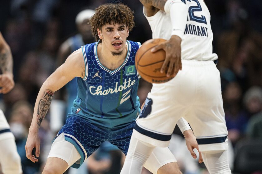 Charlotte Hornets guard LaMelo Ball (2) guards Memphis Grizzlies guard Ja Morant (12) during the second half of an NBA basketball game in Charlotte, N.C., Saturday, Feb. 12, 2022. (AP Photo/Jacob Kupferman)