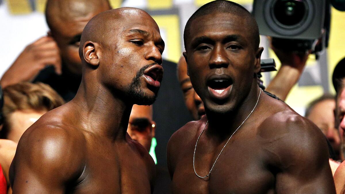 Floyd Mayweather Jr., left, and Andre Berto exchange some words as they pose following their weigh-in on Friday at the MGM Grand in Las Vegas.