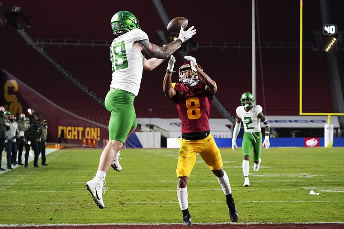 Oregon's Hunter Kampmoyer hauls in a touchdown pass in the first quarter despite pressure from USC's Chris Steele.