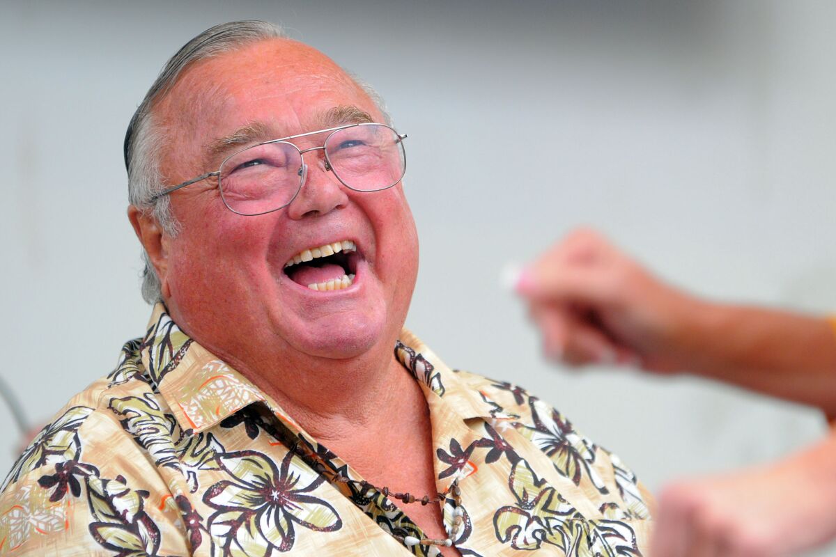  A man in a Hawaiian shirt laughs.