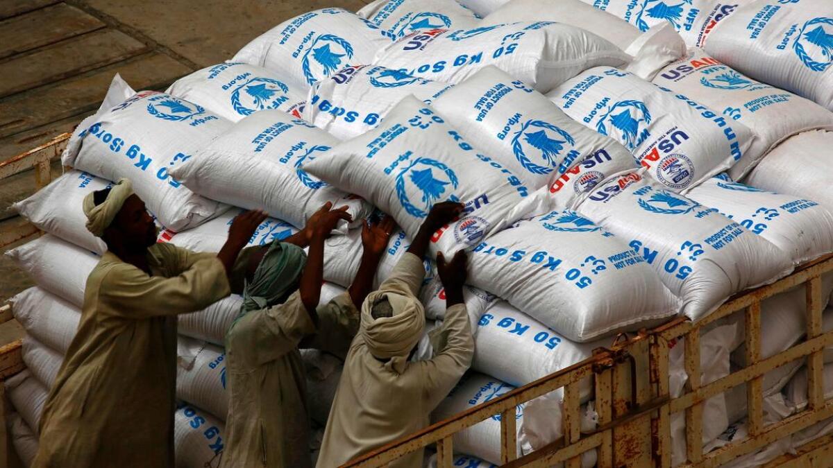 Workers at Port Sudan unload U.S. aid destined for South Sudan from the World Food Program in March.