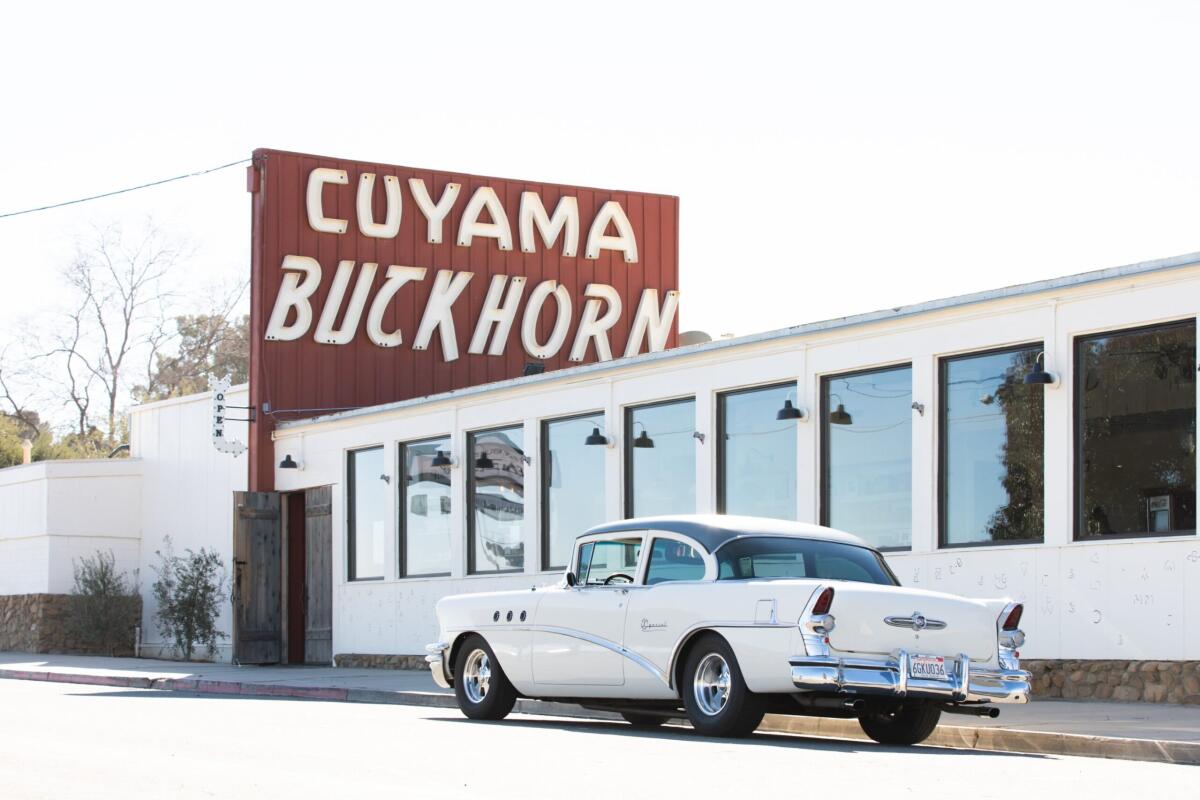 A classic car parked in front of the Cuyama Buckhorn hotel