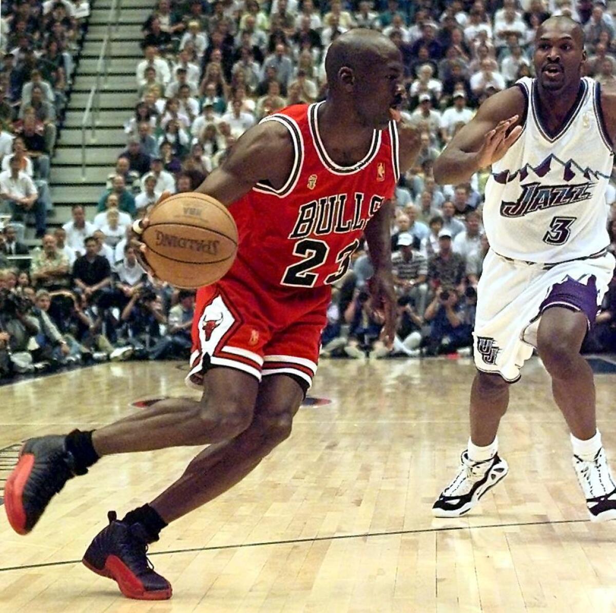 Michael Jordan of the Chicago Bulls goes to the basket past Bryon Russell of the Utah Jazz during game five of the 1997 NBA Finals at the Delta Center in Salt Lake City, Utah.