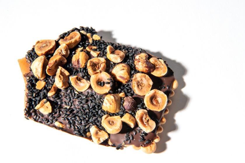 Toasted hazelnuts and black sesame seeds coat chocolate-covered toffee.