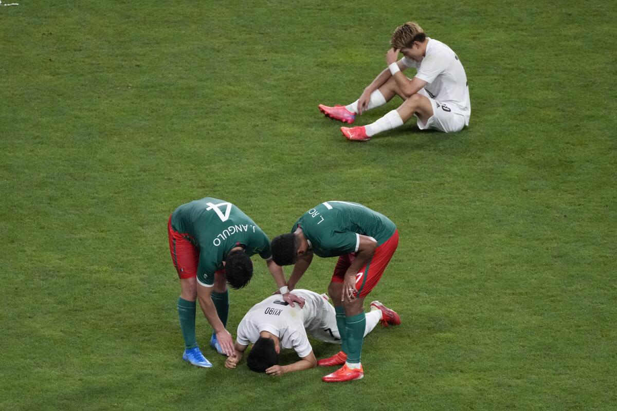 ARCHIVO - En esta foto del 6 de agosto de 2021, Jesús Angulo (4) y Luis Romo, de la selección de México.