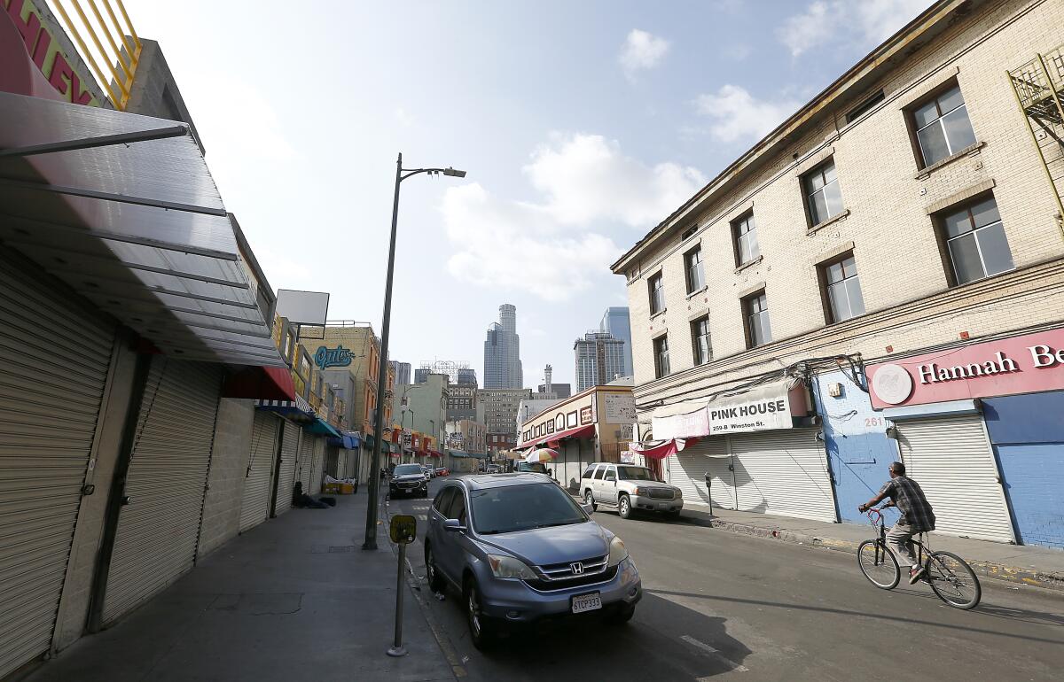Closed businesses line Winston Street in the wholesale district of Los Angeles. Gov. Gavin Newsom and others are beginning to talk about how the economy could restart.
