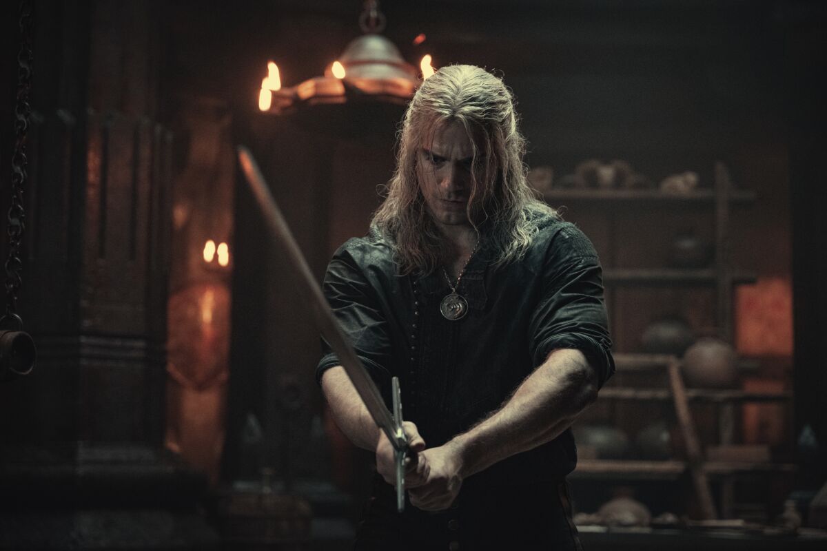A man with stringy blond hair holding a sword