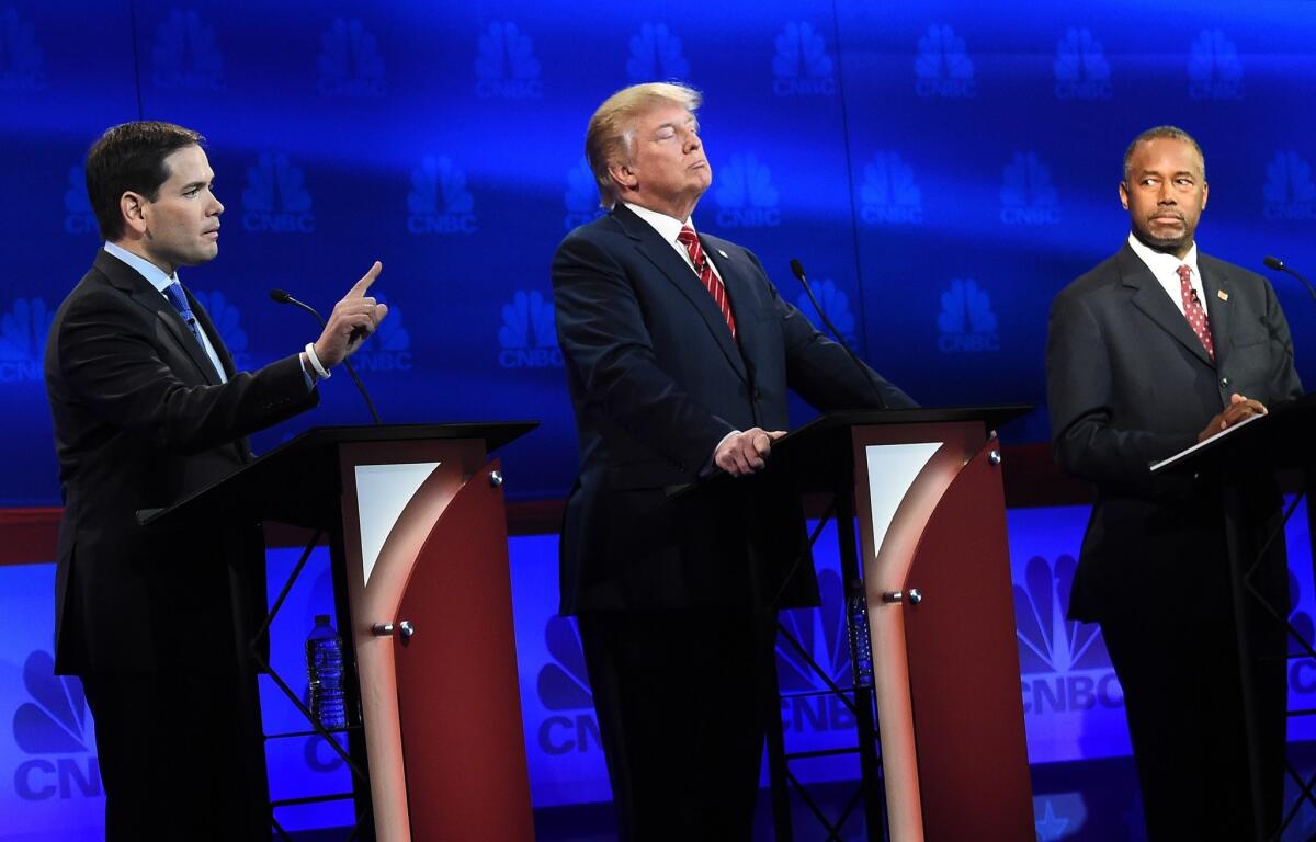 Republican Presidential hopeful Marco Rubio (L) speaks as Donald Trump (C) and Ben Carson look on during the CNBC Republican Presidential Debate at the Coors Event Center at the University of Colorado in Boulder, Colo.
