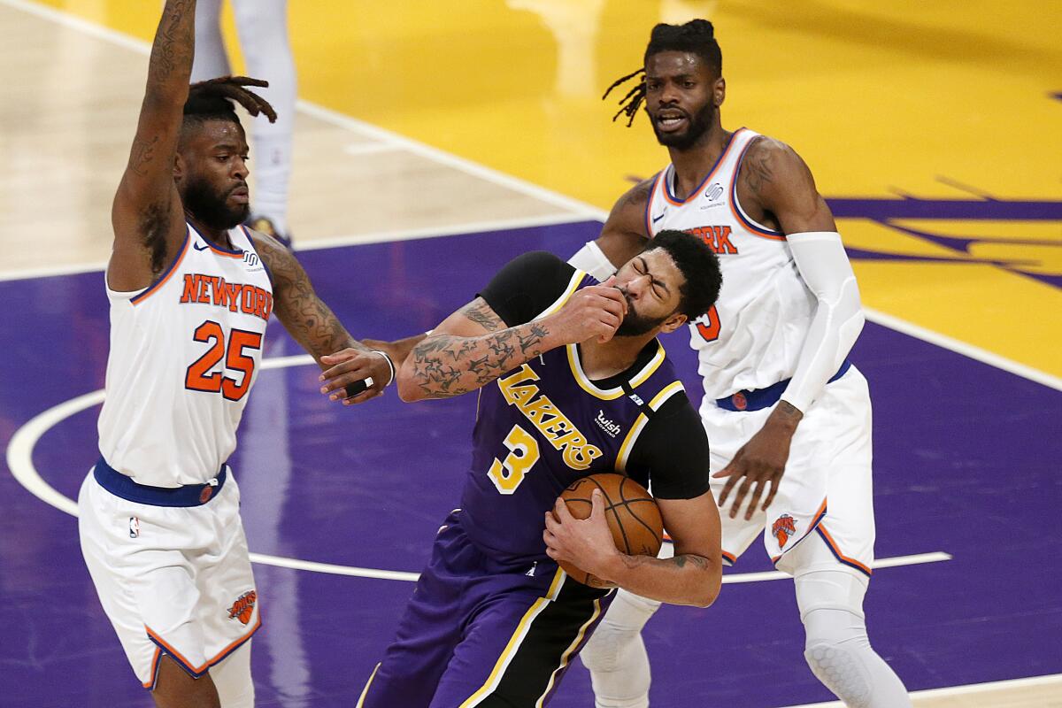 Anthony Davis is fouled by Reggie Bullock and Nerlens Noel in the fourth quarter.