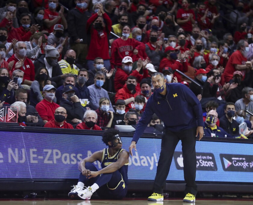 Michigan coach Juwan Howard taps his son, guard Jace Howard, on the shoulder during the second half of the team's NCAA college basketball game against Rutgers on Tuesday, Jan. 4, 2022, in Piscataway, N.J. (Andrew Mills/NJ Advance Media via AP)