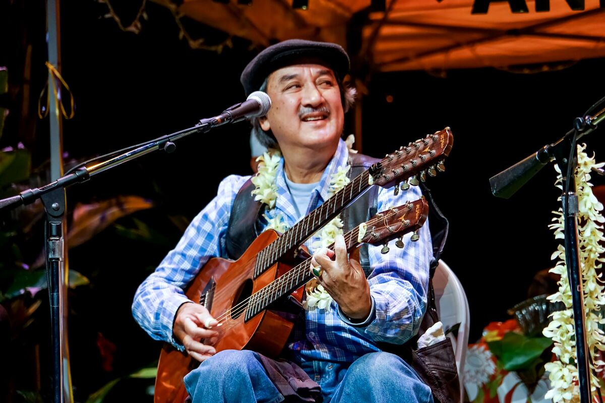 George Kua playing an instrument on stage.