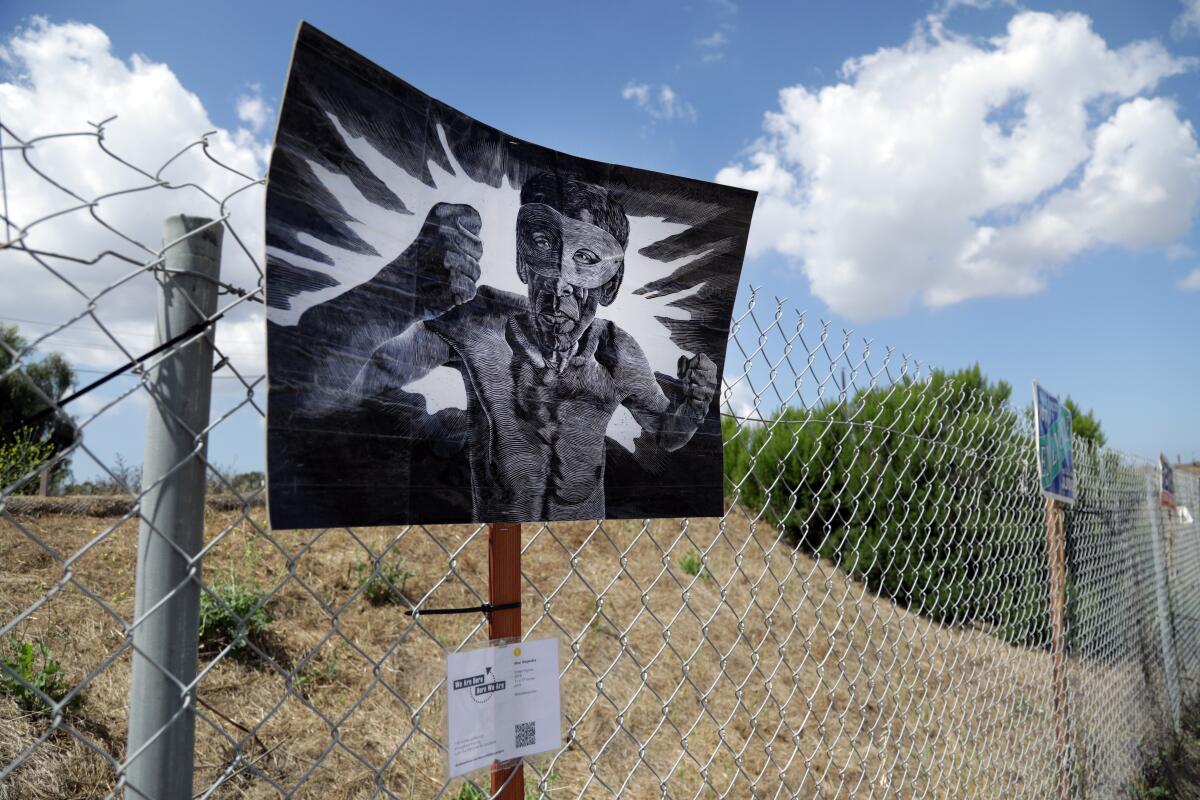 Abel Alejandre's "Street Fighter" on display on a Signal Hill fence. The gallery Durden and Ray has enlisted 100 artists to place their work in public around Los Angeles County.