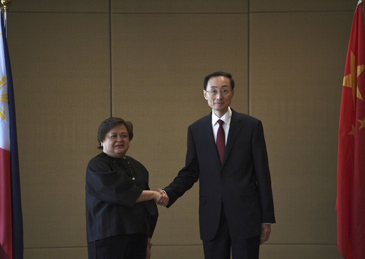 Theresa Lazaro, left, Philippines' Undersecretary for Bilateral Relations and Asian Affairs of the Department of Foreign Affairs, shake hands with Sun Weidong, China's Vice Foreign Minister, prior to the start of the Philippines-China Foreign Ministry consultation meeting at a hotel in Manila Thursday, March 23, 2023.(Ted Aljibe/Pool via AP)