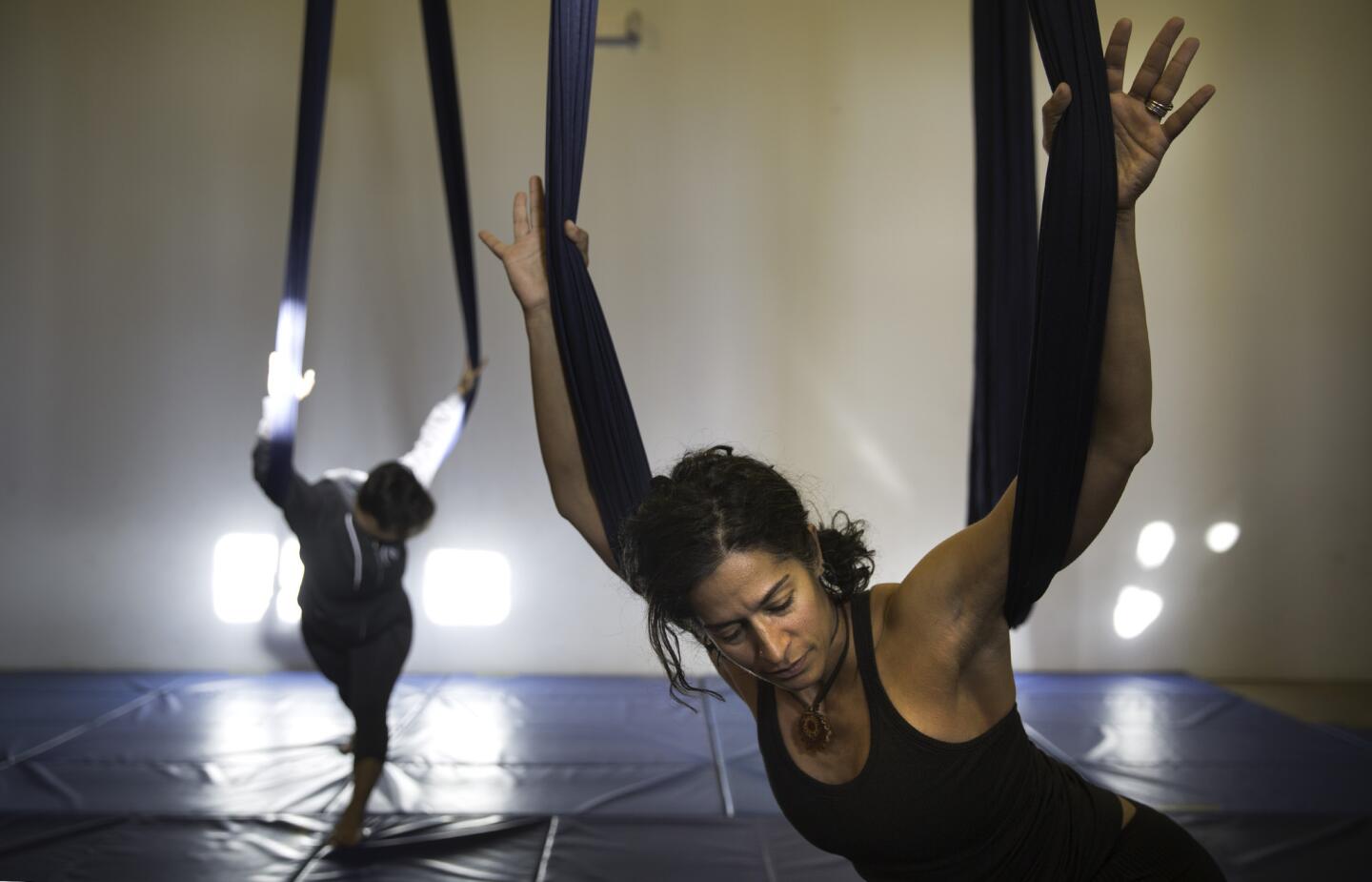 Instructor Veronica DeSoyza, right, leads a morning aerial yoga class at Kinship in Highland Park. Shelby Williams-Gonzalez, left, holds a pose.