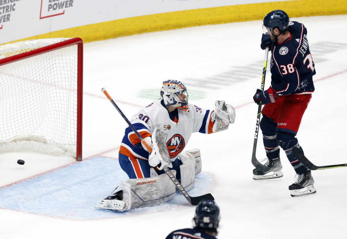 Columbus Blue Jackets forward Boone Jenner, right, scores past New York Islanders goalie Ilya Sorokin during overtime in an NHL hockey game in Columbus, Ohio, Friday, March 24, 2023. The Blue Jackets won 5-4. (AP Photo/Paul Vernon)