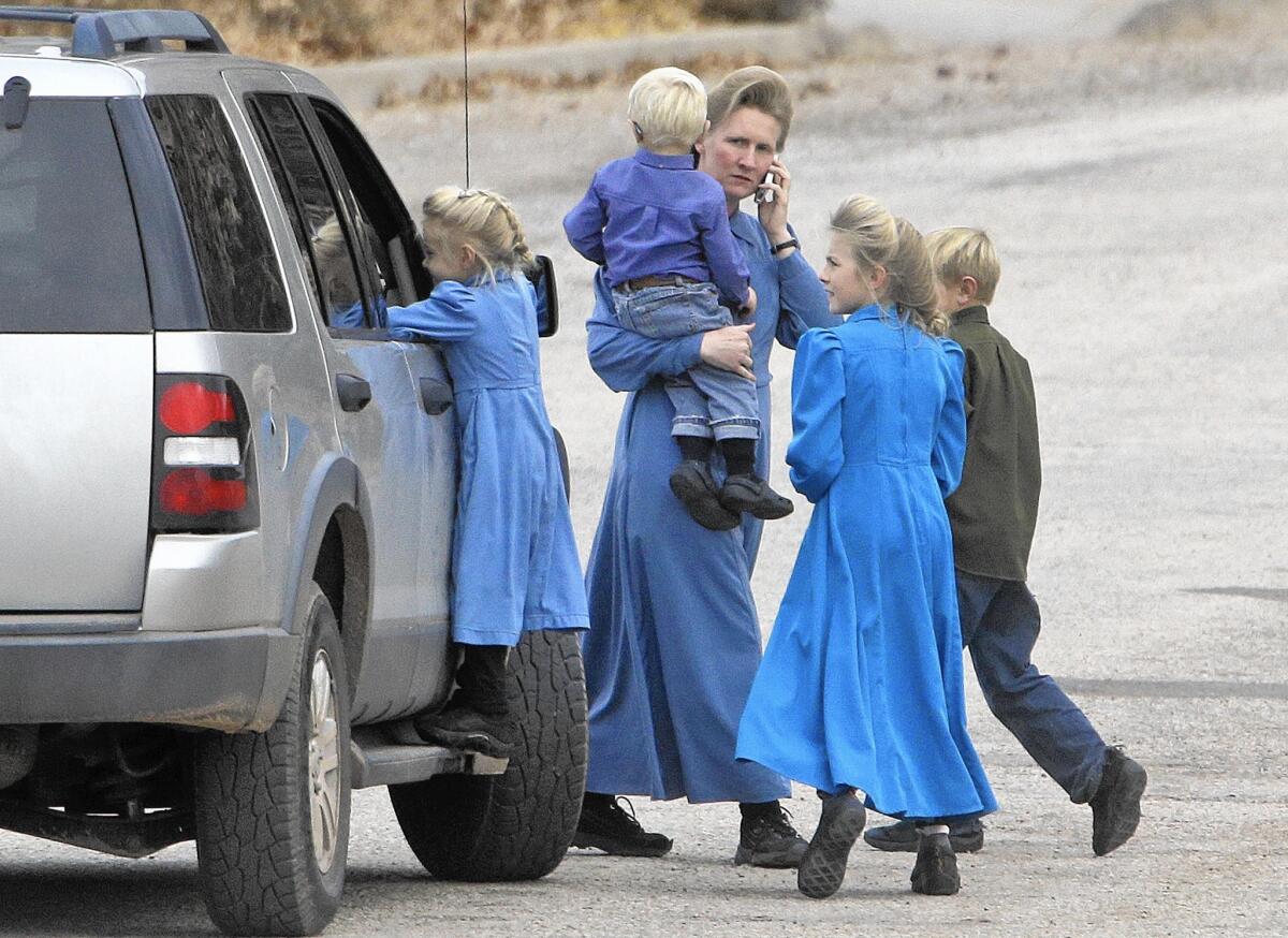 A woman and children in Hildale, Utah, in 2014. In its civil suit, the U.S. government says Hildale and Colorado City, Ariz., discriminated against people who didn’t belong to the Fundamentalist Church of Jesus Christ of Latter-Day Saints.