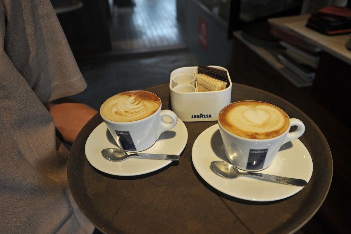 A waiter brings drinks to customers at a coffee shop in Yangon, Myanmar. A new study finds that drinking three to five cups a coffee a day is associated with lower rates of coronary artery calcium.