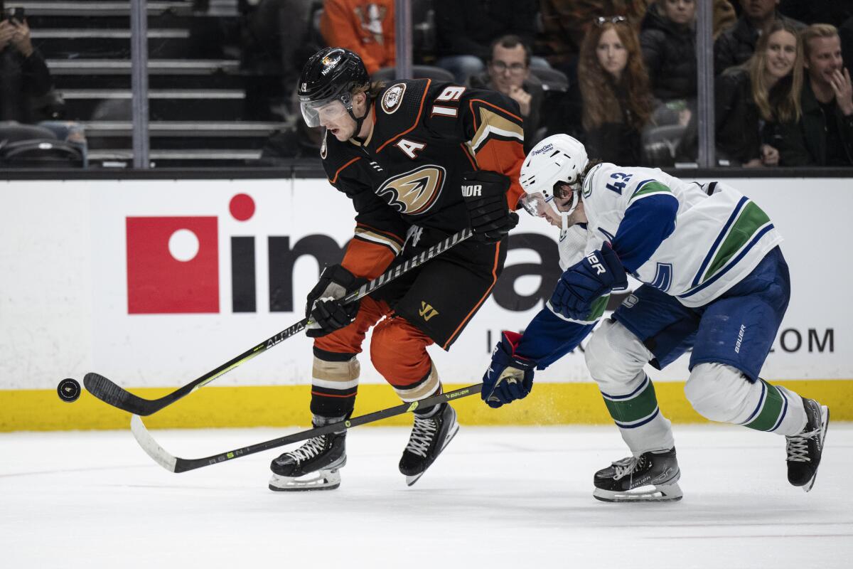 Ducks right wing Troy Terry controls the puck in front of Vancouver Canucks defenseman Quinn Hughes.
