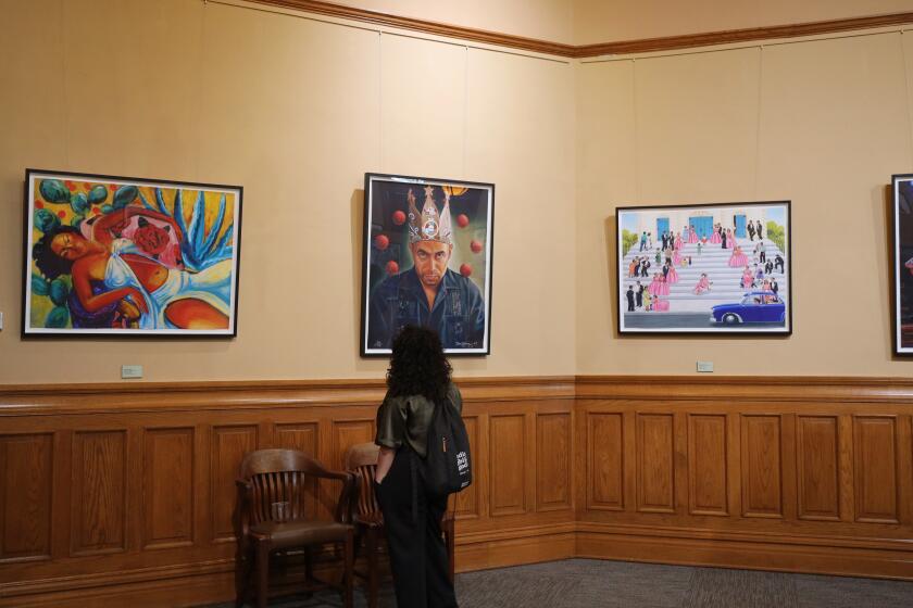 Viewers admire the Chicano Collection art exhibit at the Old Orange County Courthouse in Santa Ana.