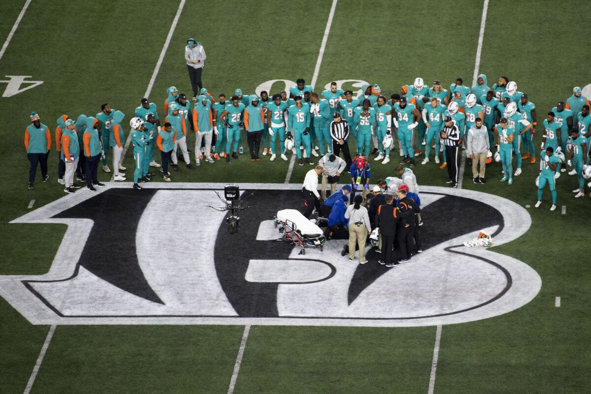 Los Dolphins de Miami observan la atención a su compañero, el quarterback Tua Tagovailoa (1), quien sufrió una conmoción cerebral durante el partido del jueves 29 de septiembre de 2022, ante los Bengals de Cincinnati (AP Foto/Emilee Chinn)