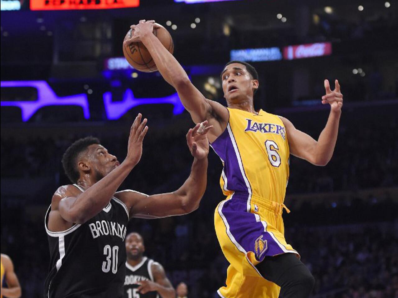 Lakers guard Jordan Clarkson passes the ball behind him while under pressure from Nets forward Thaddeus Young during the first half of a game on March 1.