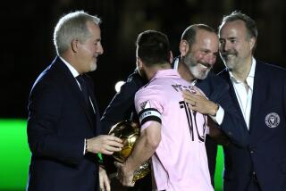 Inter Miami forward Lionel Messi is hugged by MLS Commissioner Don Garber, center right.