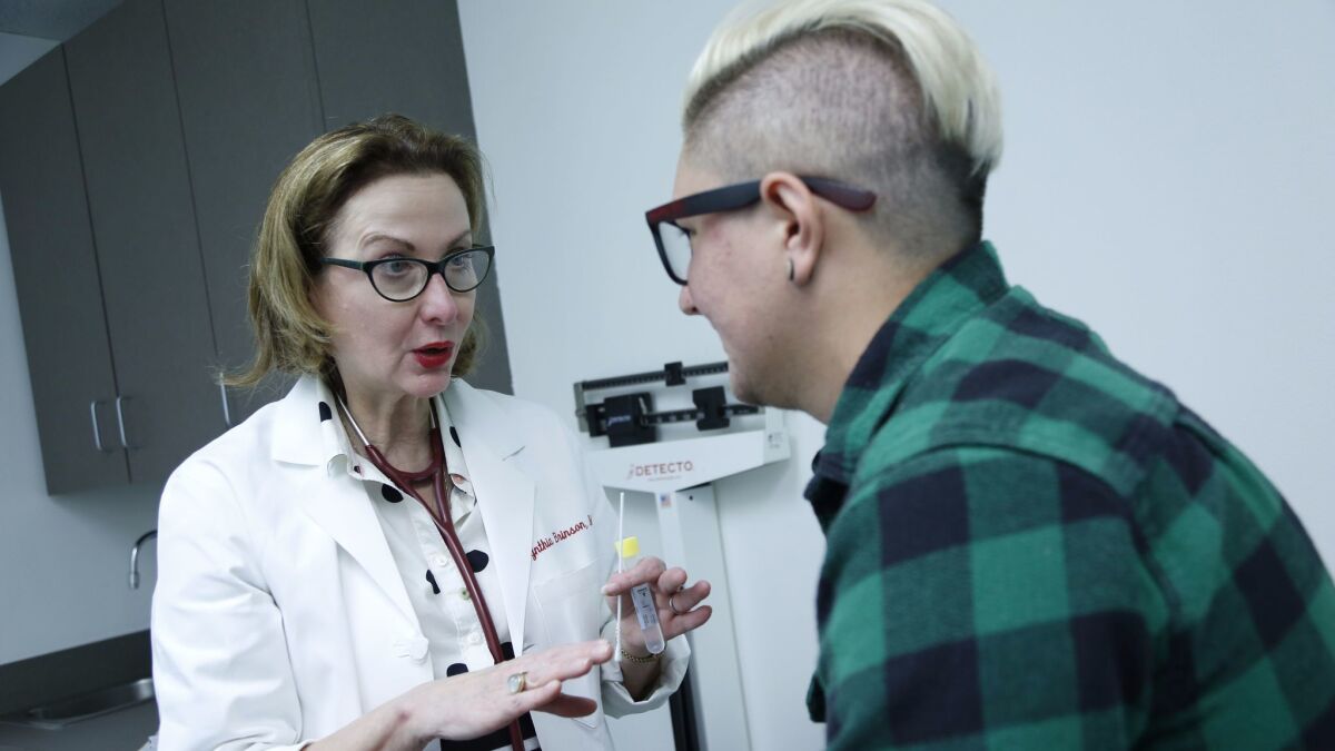 Dr. Cynthia Brinson, medical director at the Kind Clinic, consults with a transgender patient, Peter Haley.