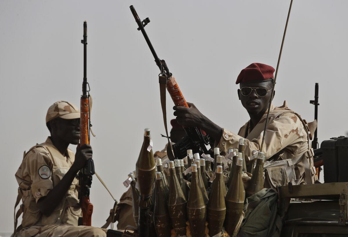 Paramilitary soldiers in Sudan hold weapons.