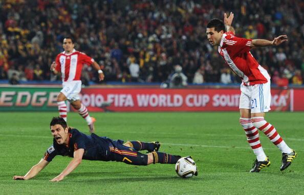 Antolin Alcaraz of Paraguay brings down David Villa of Spain in the penalty area and gives away a penalty kick during the 2010 FIFA World Cup South Africa Quarter Final match between Paraguay and Spain at Ellis Park Stadium on July 3, 2010 in Johannesburg, South Africa.