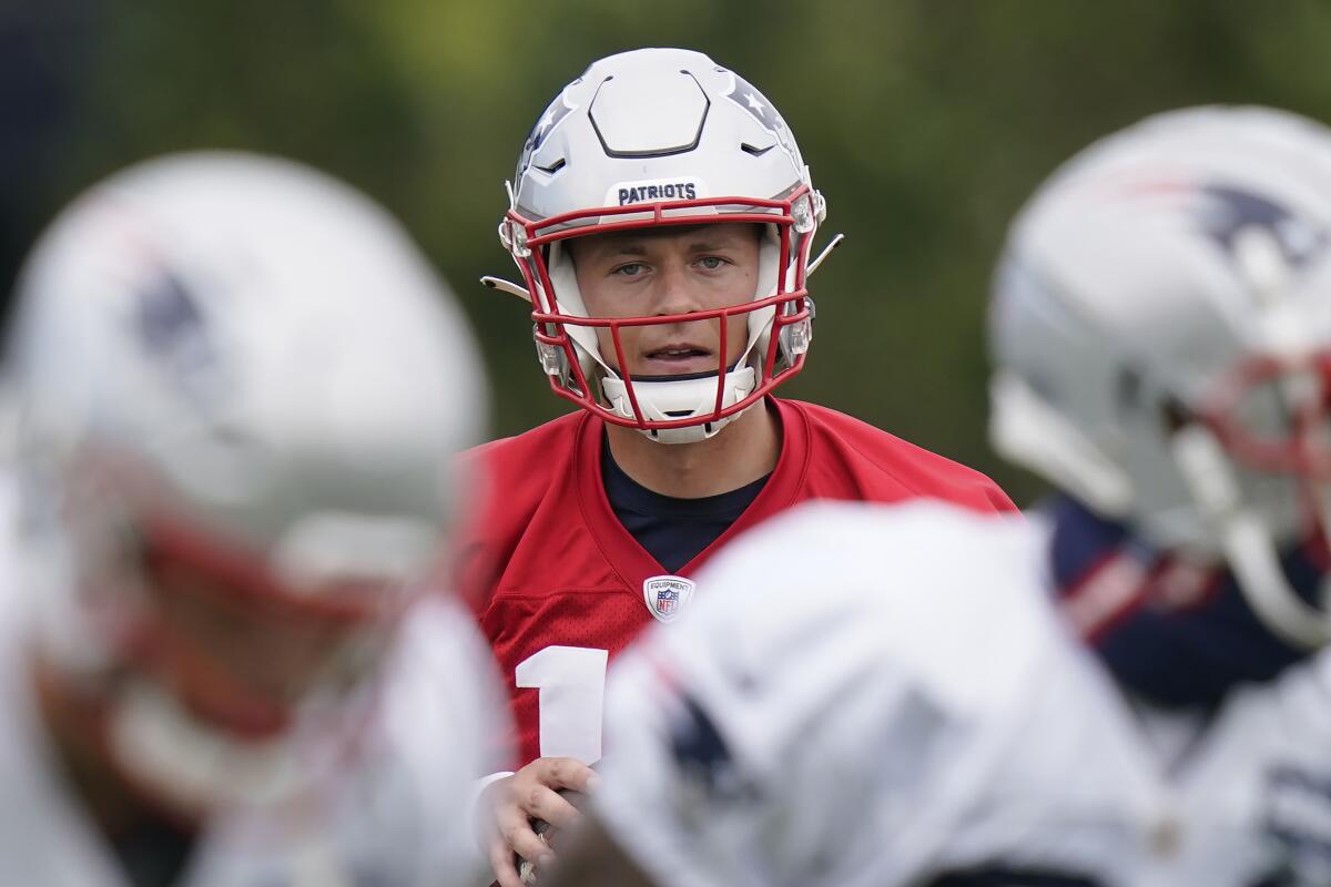 New England Patriots quarterback Mac Jones looks for an opening from the pocket while performing field drills during an NFL football practice, Tuesday, Aug. 31, 2021, in Foxborough, Mass. The Patriots released quarterback Cam Newton on Tuesday, Aug. 31, clearing the way for rookie Mac Jones to open the season as New England's quarterback, according to a person with knowledge of the move. The person spoke to the Associated Press on condition of anonymity because the decision has not been announced. (AP Photo/Steven Senne)
