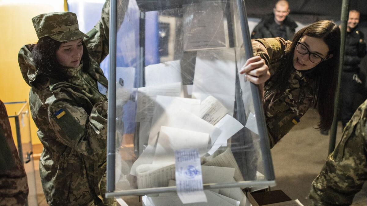 Ukrainian soldiers and local elections officials open a ballot box in a tent used as a polling station in Mariinka, in eastern Ukraine's Donetsk province on Sunday.