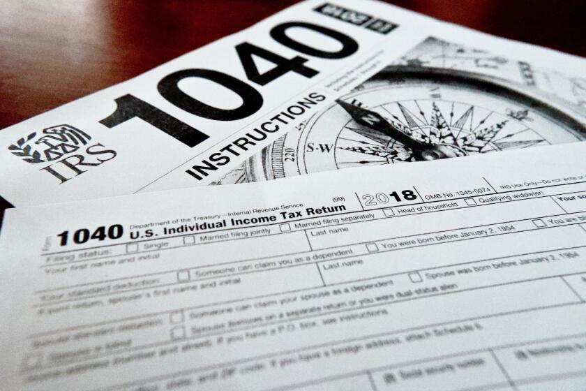 FILE- Internal Revenue Service taxes forms are seen on Feb. 13, 2019. Unlike a deduction, which decreases the income on which you’ll be taxed, a tax credit reduces your overall tax due. The result can mean hundreds of dollars knocked off your bill — or added to your refund. (AP Photo/Keith Srakocic, File)