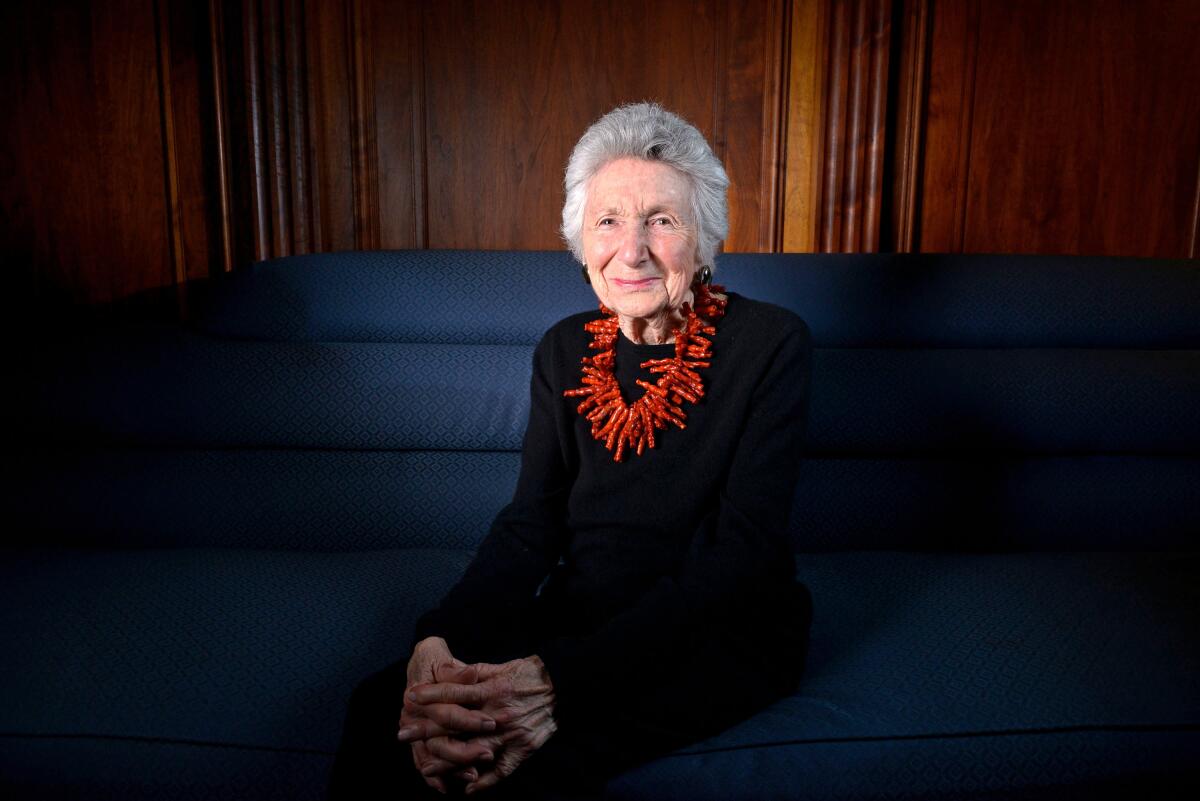 A well-dressed woman seated on a couch.