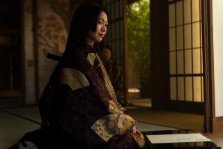 A woman in a kimono sitting in a room with tatami floor